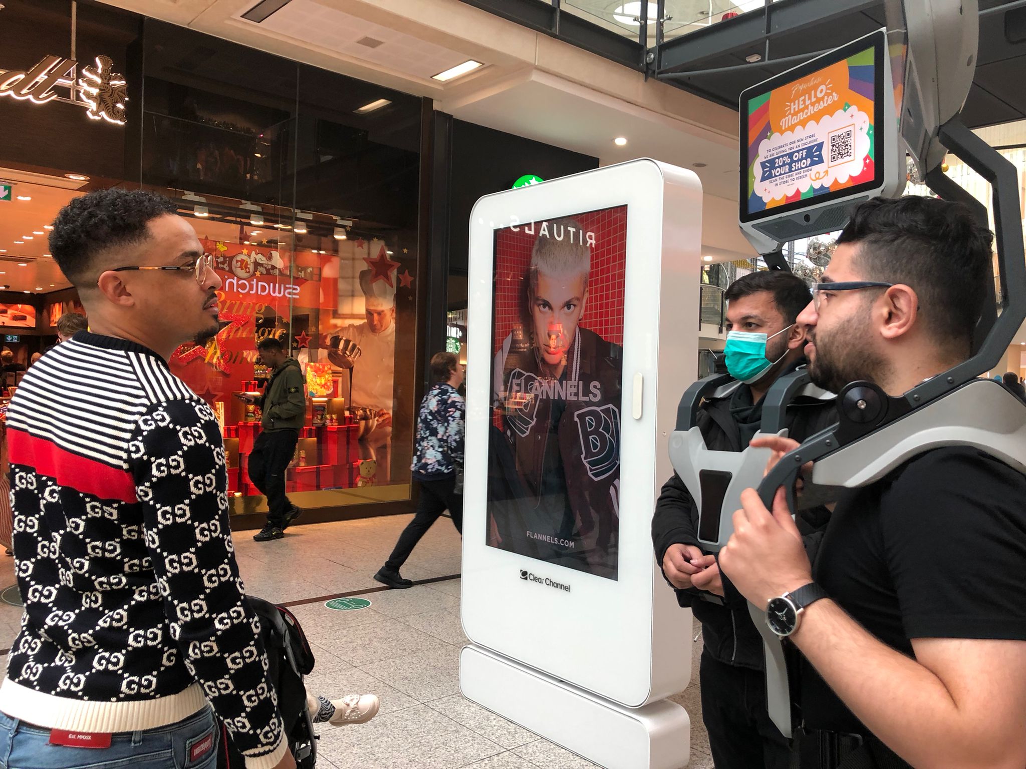 ad walkers speaking with man in shopping mall